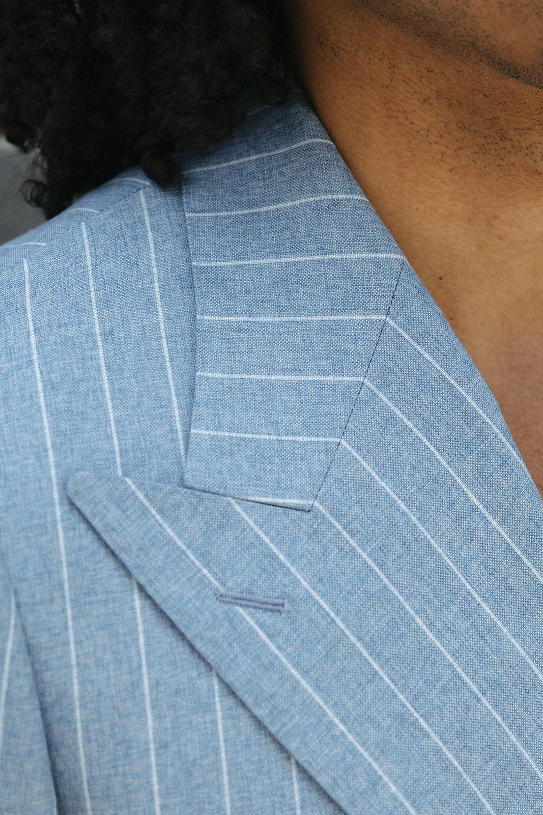 Close-up of a light blue pinstripe jacket shoulder and lapel