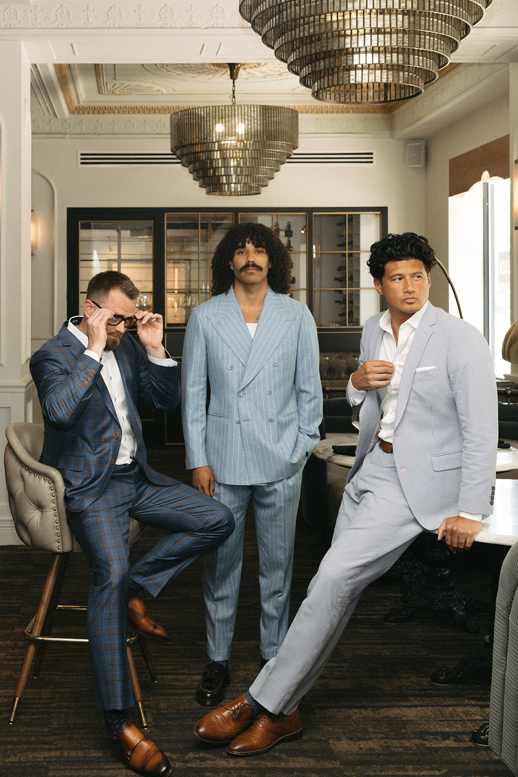 Three men in custom suits in a restaurant lounge