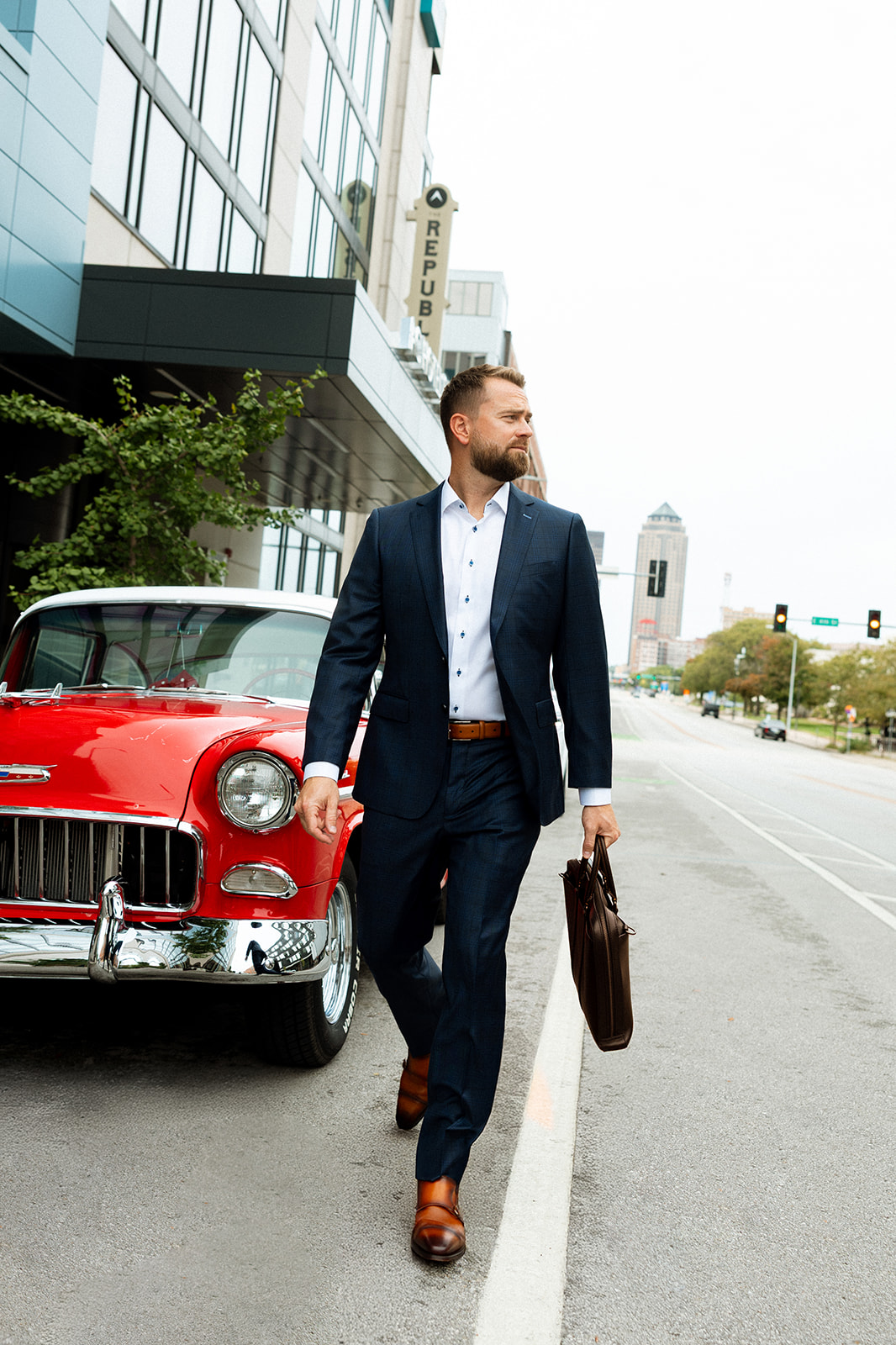 Man in a custom navy suit on a downtown Des Moines street