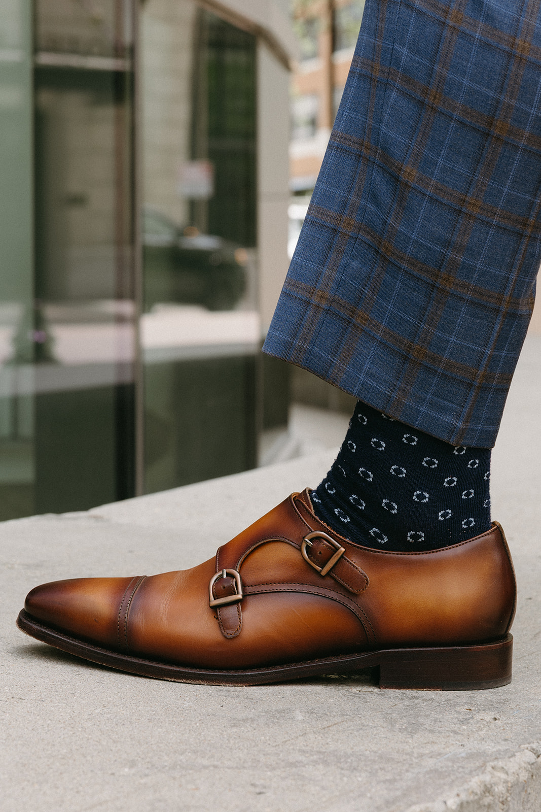Custom plaid trouser break over a brown double monk shoe