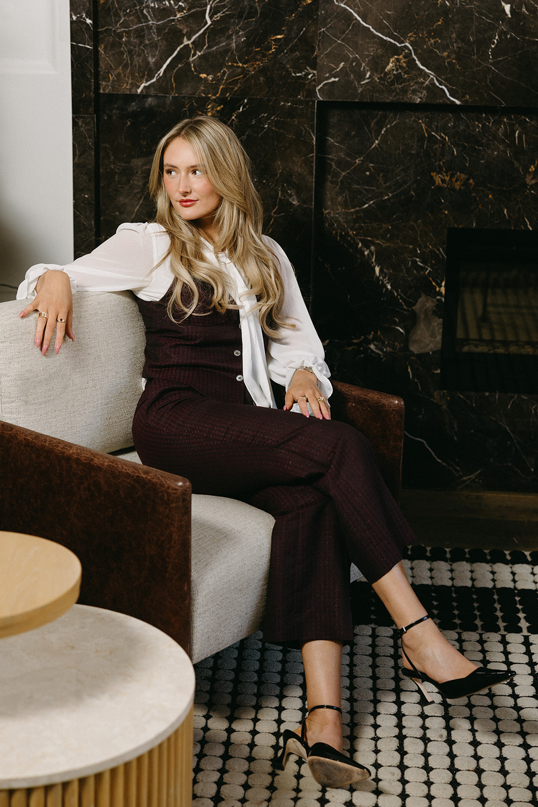 Woman in a custom bow-sleeve blouse and burgundy suit