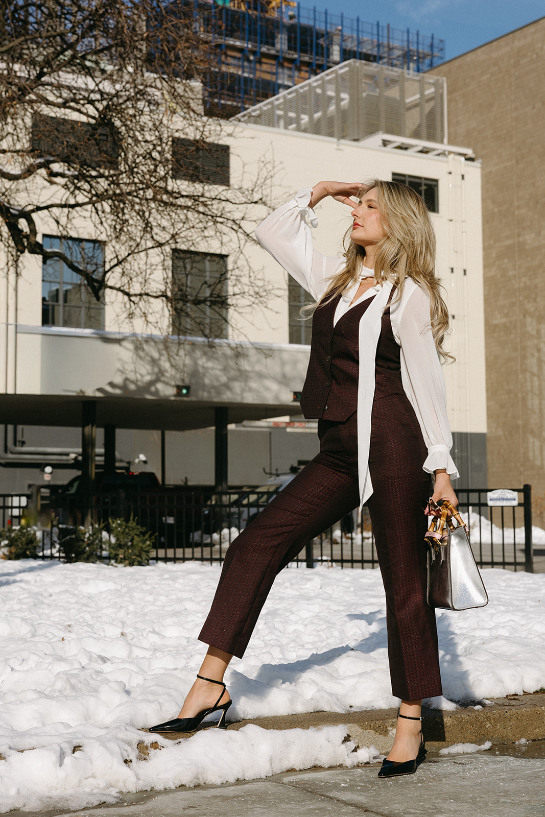 Woman in a custom burgundy suit outdoors
